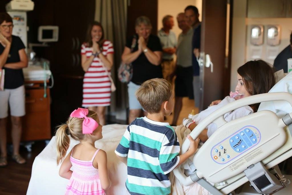 Group gathered in hospital room to welcome new baby.