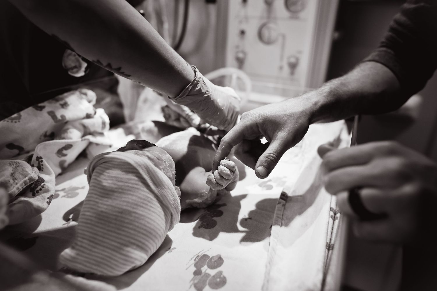 Black and white image of medical examination of newborn baby in hospital.