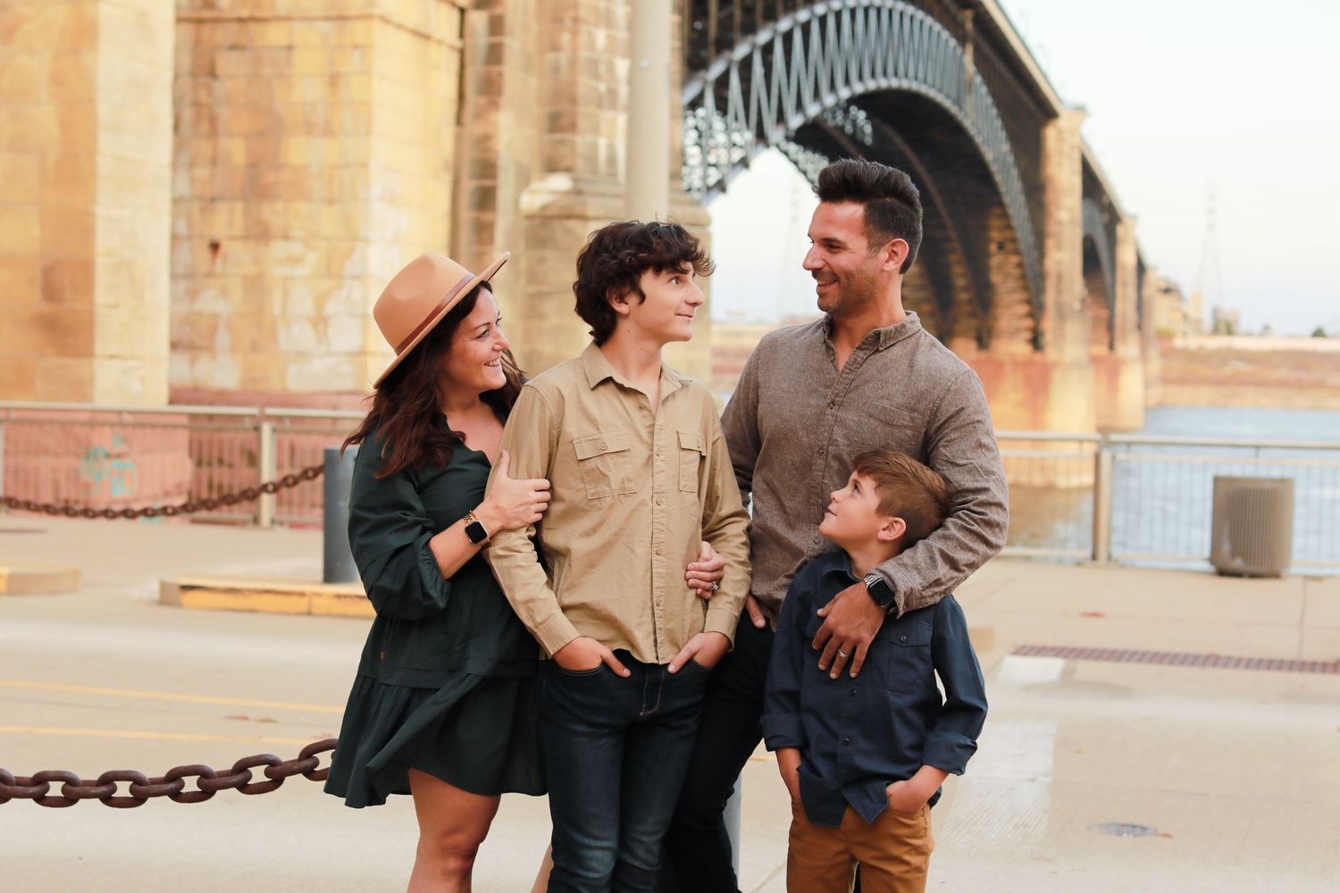 Candid family photos taken against rustic brick architectural backdrop.