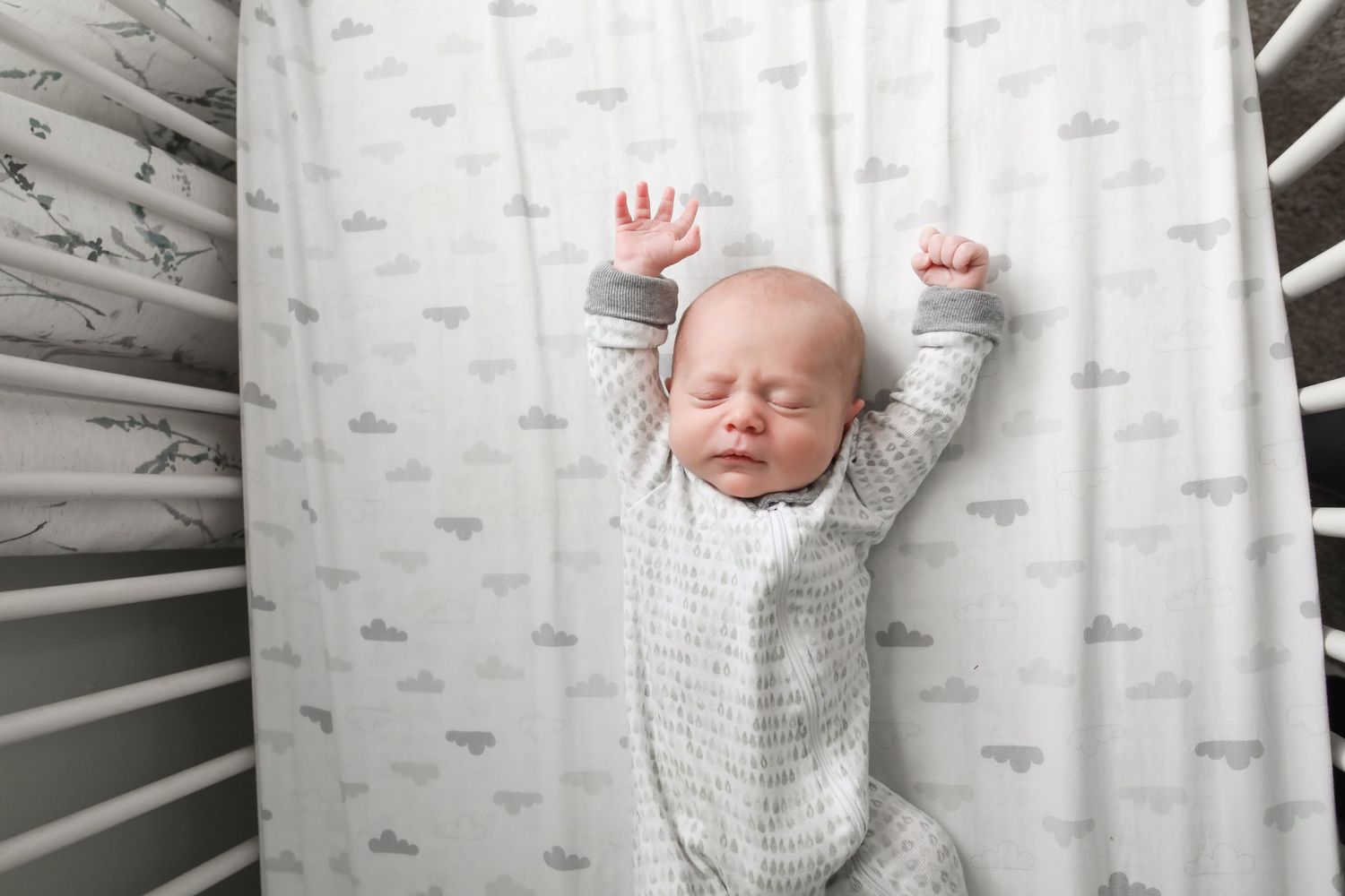 Sweet baby sleeping against gray woodland wallpaper background during photo shoot.