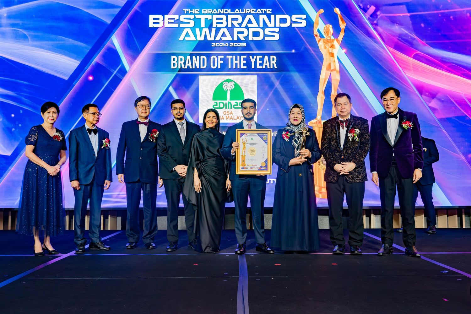 Award winners and presenters stand together on stage at the Best Brands Awards ceremony with blue lighting effects.