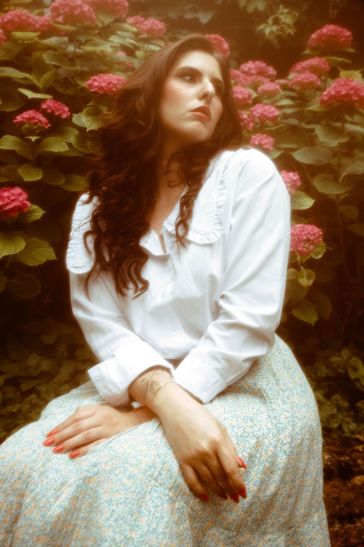 Portrait d'une femme assise dans les fleurs dans un parc de la Loire, près de Saint-Étienne, séance photo artistique