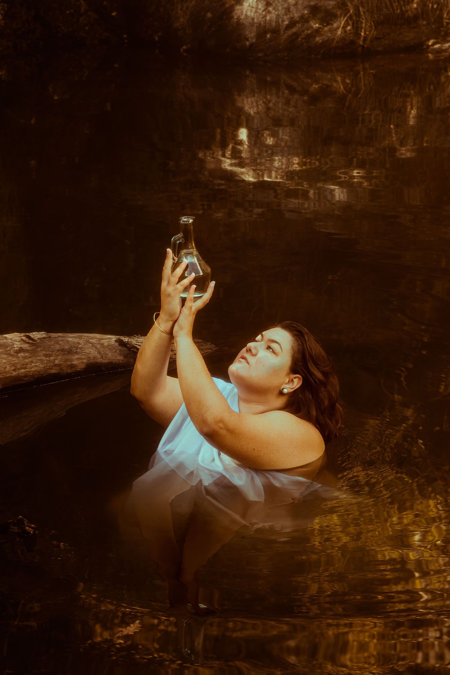 Séance photo artistique dans un lac de la Loire, femme posant comme une divinité des eaux calmes