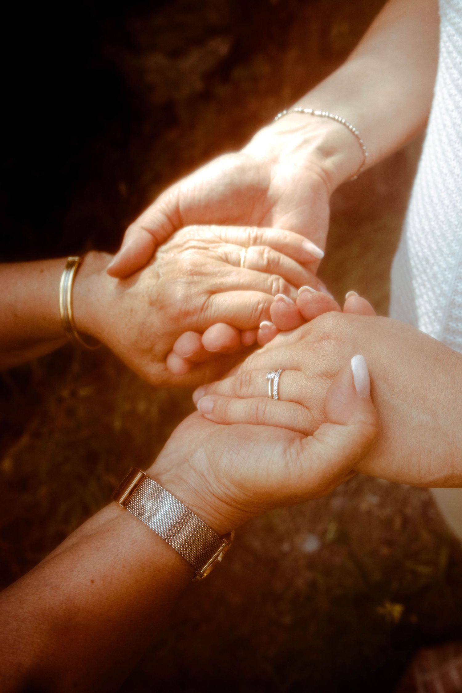 Détail de mains d'une mère et sa fille adulte qui se tiennent les mains lors d'un séance photo en extérieur dans la Loire
