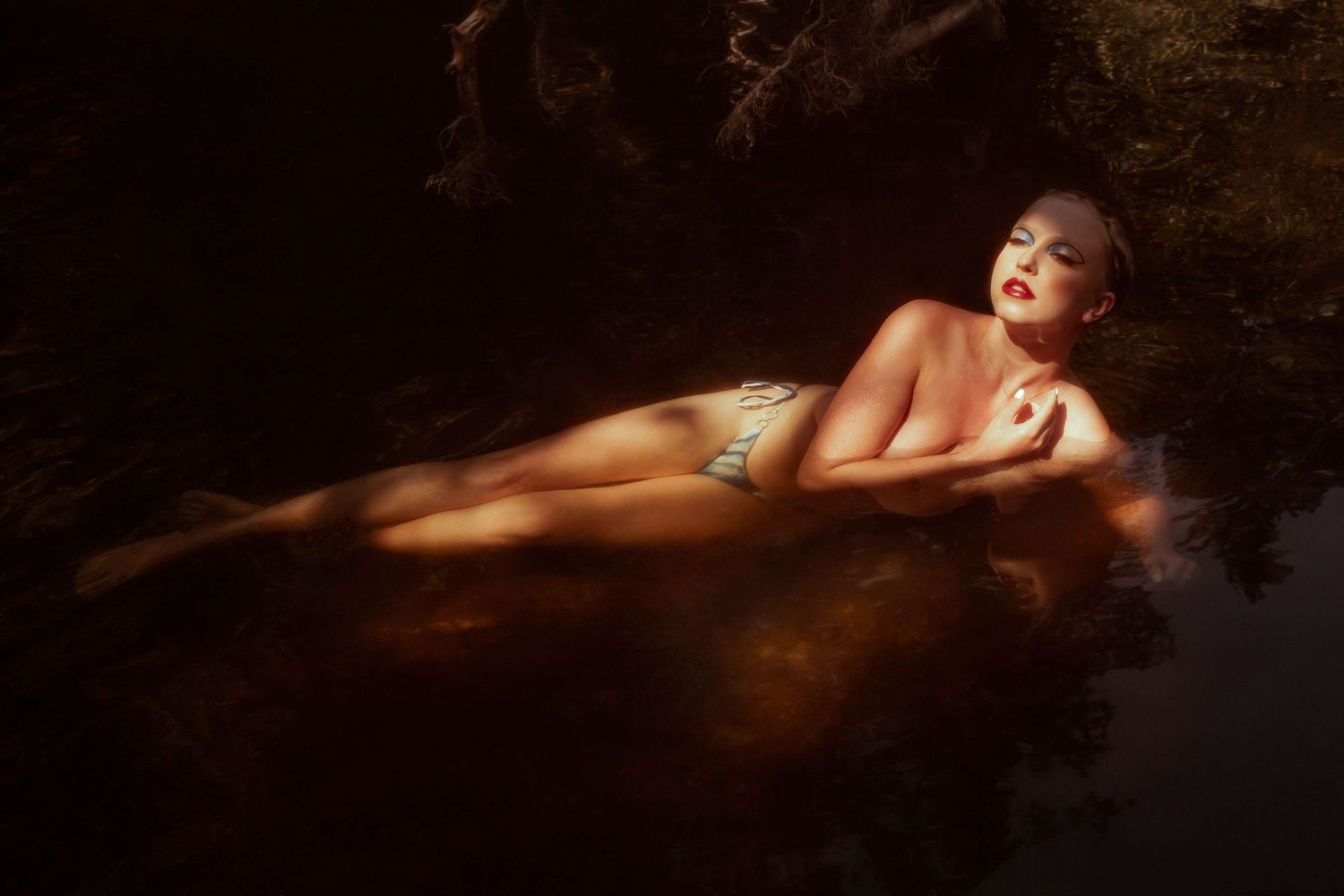 Femme dans l’eau au coucher du soleil, capturée comme une déesse de l’eau, sauvage et libre, séance photo artistique près de Saint-Étienne