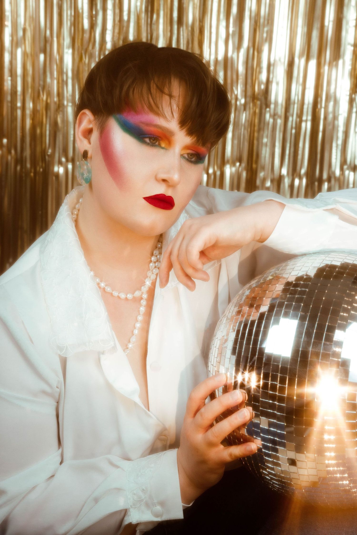Photo artistique d’une femme en tenue flashy et maquillage vibrant, dans un décor inspiré des années 80, séance photo Loire