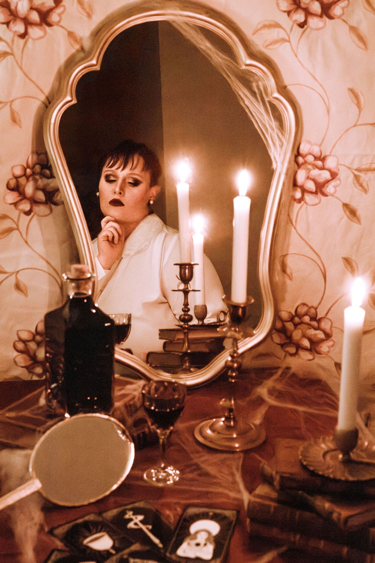 Photographie mystique montrant une femme devant un miroir et des bougies lors d'une séance photo artistique thème Halloween, dans la Loire