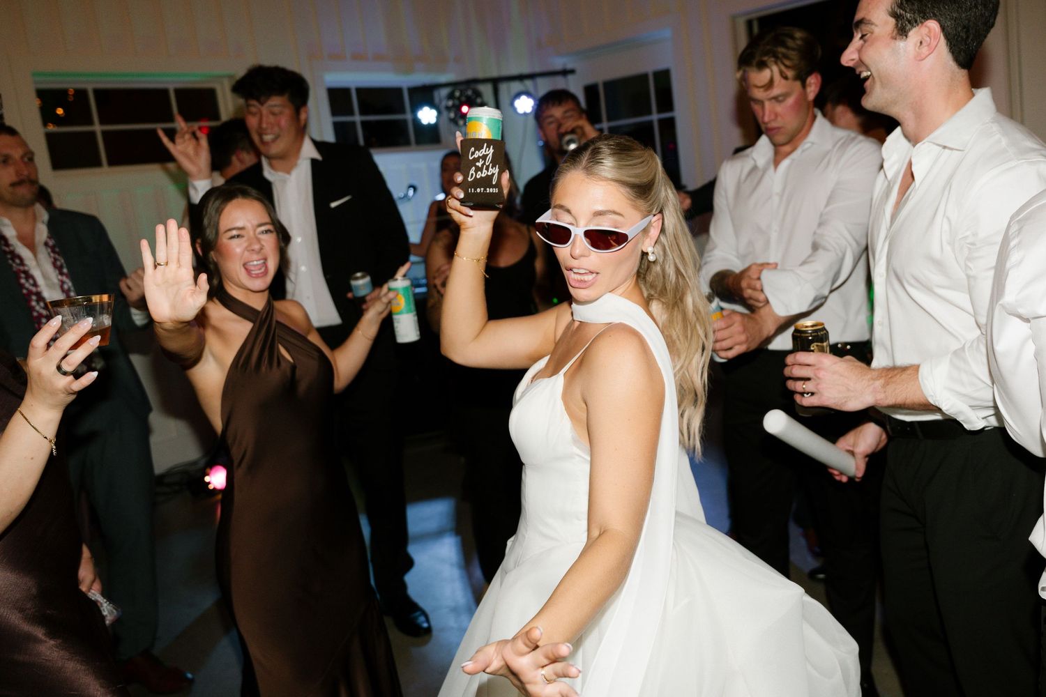 A lively dance floor at a wedding reception shows guests dancing and celebrating together in formal attire.