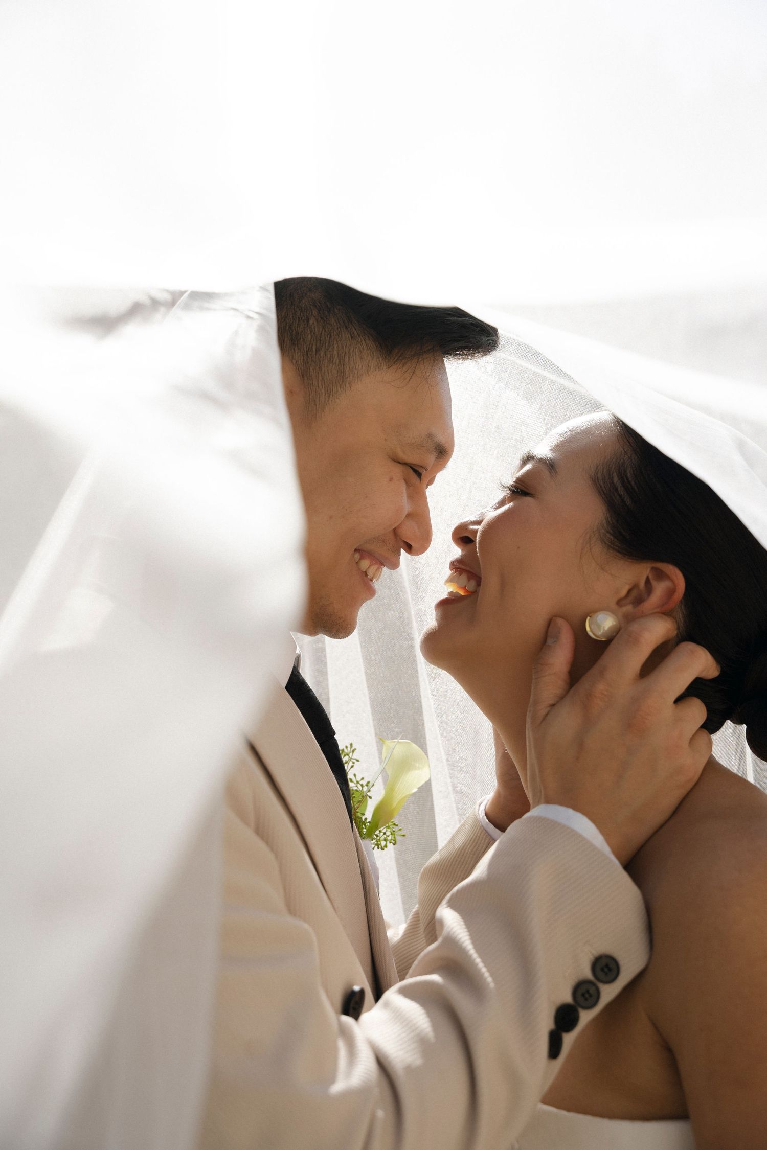 A romantic wedding couple sharing intimate kisses in a series of soft white portraits.