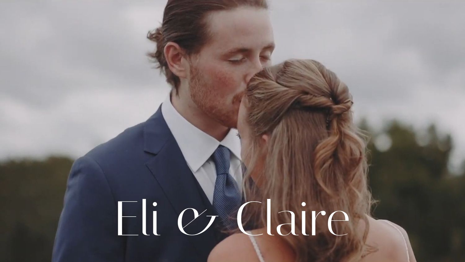 A romantic couple embraces in an outdoor setting during a wedding photoshoot at sunset.