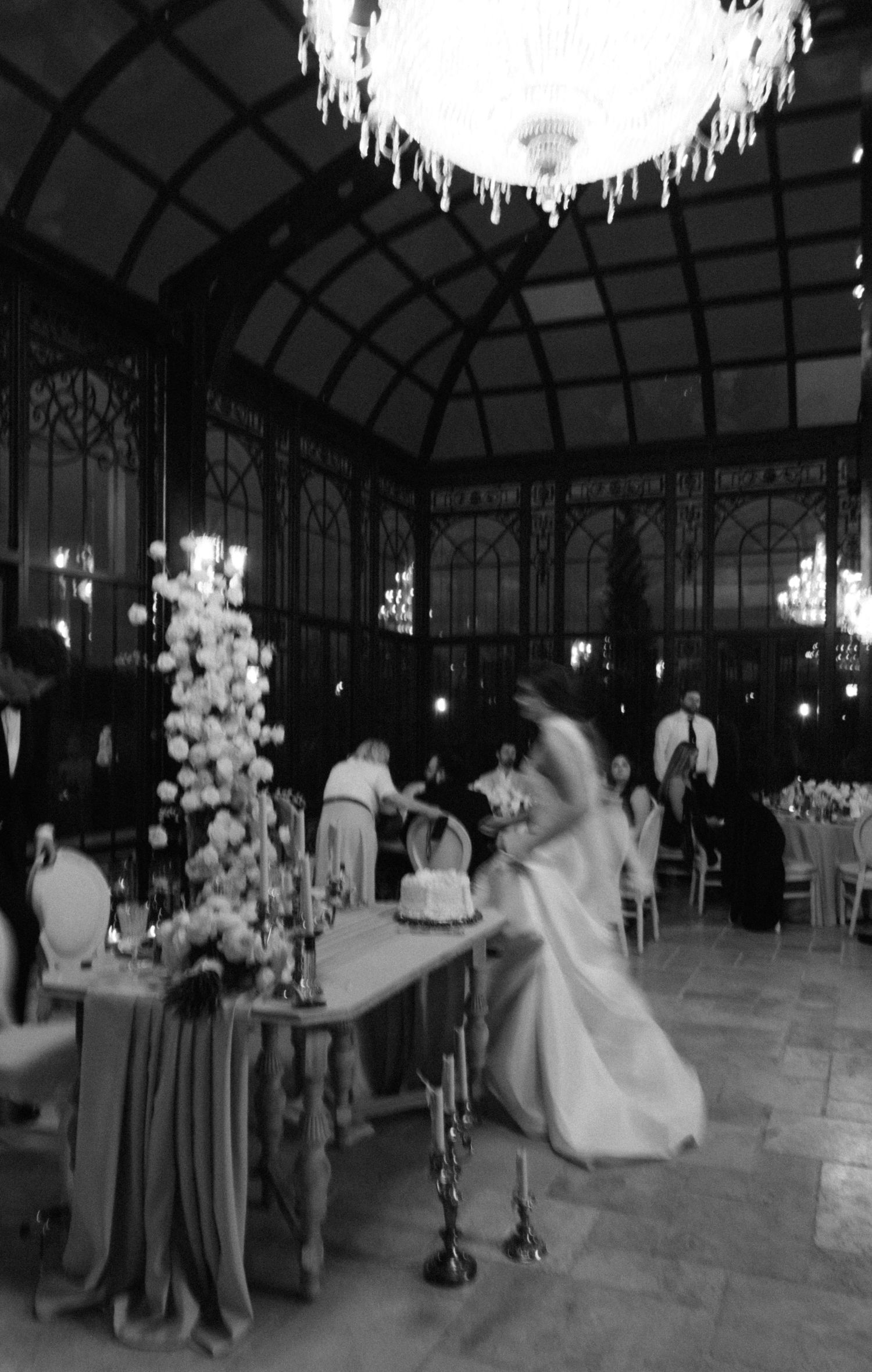 Elegant wedding reception in a grand ballroom with crystal chandeliers and ornate architectural details.