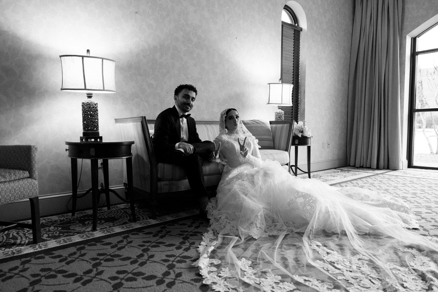 A wedding dress flows across a sunlit hotel room floor in a sequence of five connected black and white photographs.