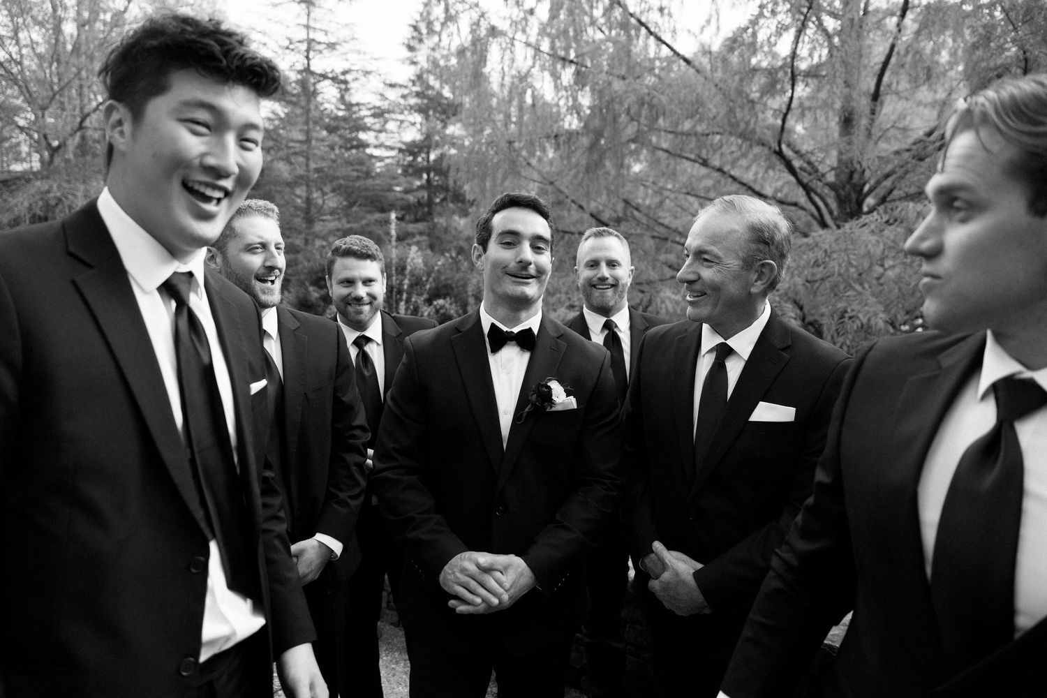 A series of black and white photos showing people in formal attire laughing and socializing at an event.