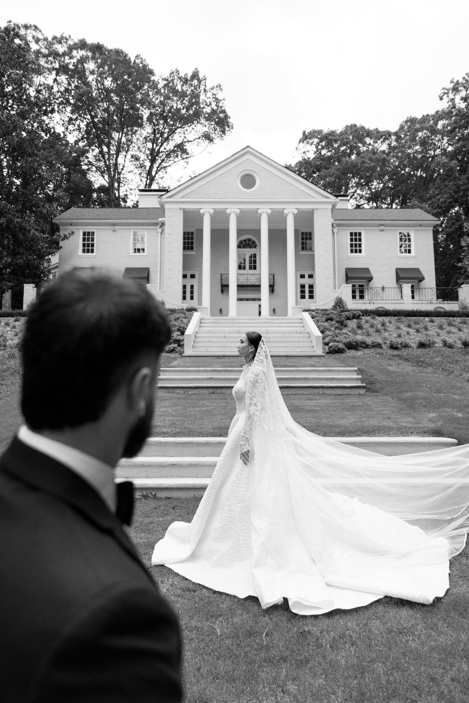 A stunning wedding photo series showing a flowing white bridal gown against a classic white columned building exterior.