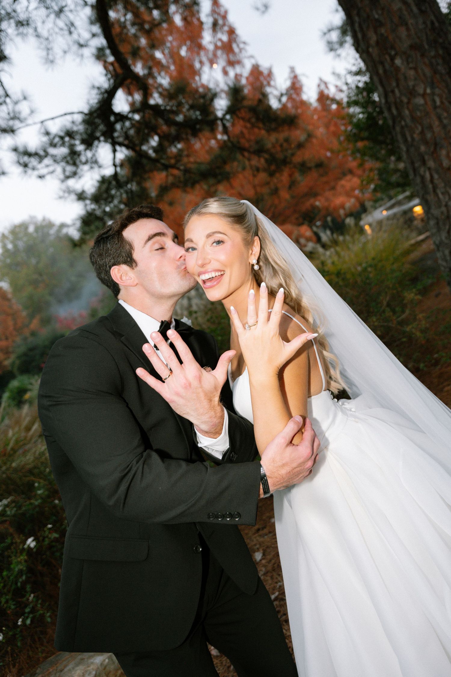 Joyful wedding couple sharing a romantic moment outdoors during autumn.