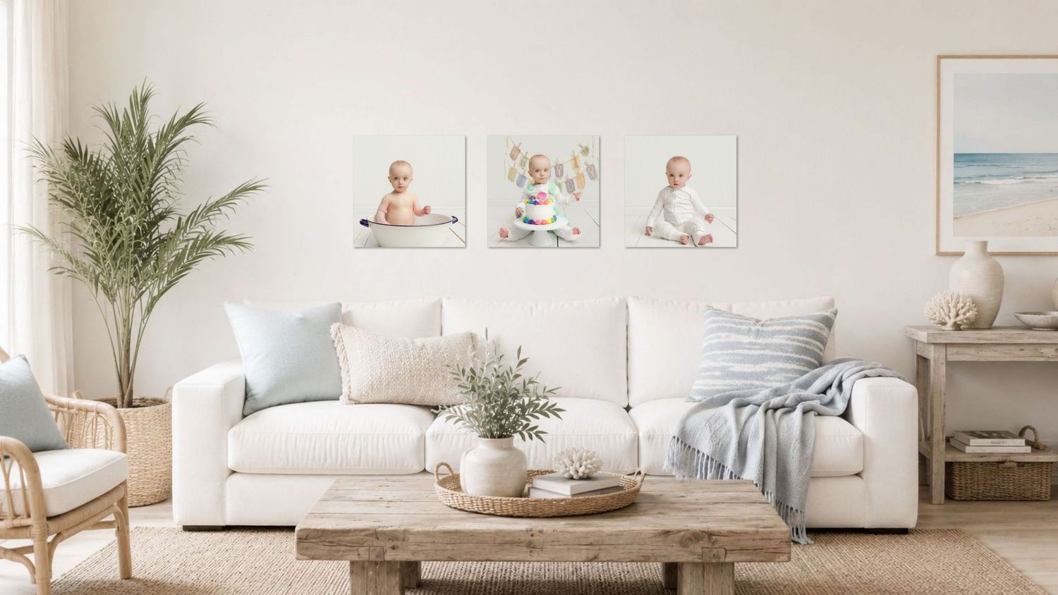 Bright living room with white sofa, coastal decor, and three baby portrait canvas prints displayed on the wall.