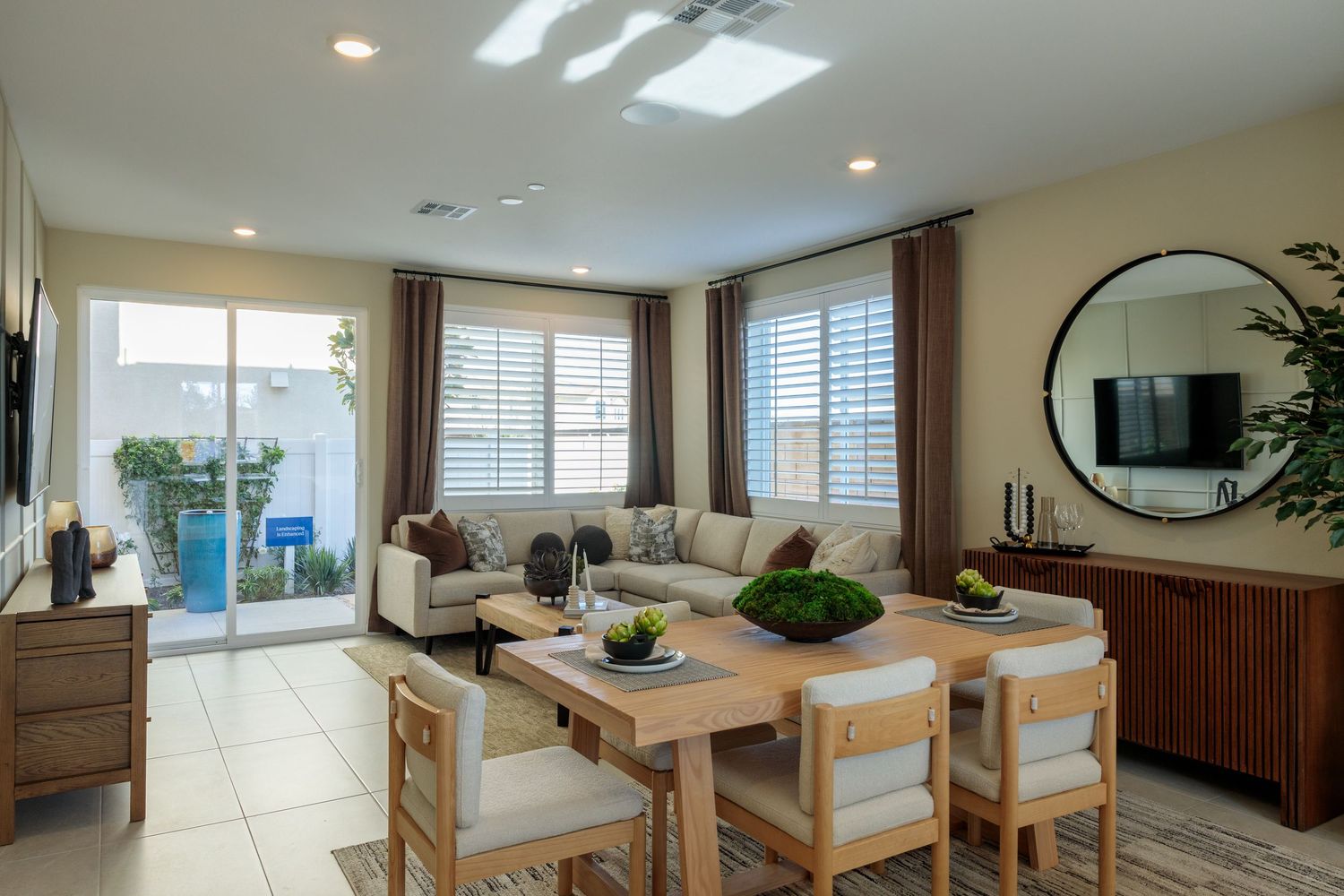 Modern apartment interior with open floor plan showcasing natural light through large windows and contemporary furnishings.