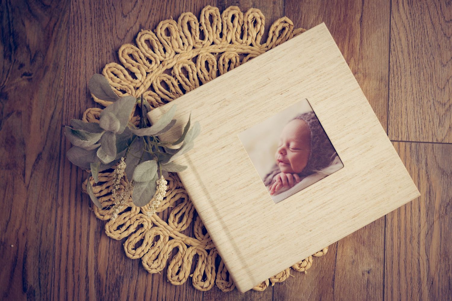 A vintage photo album with decorative gold doily on wooden floor.