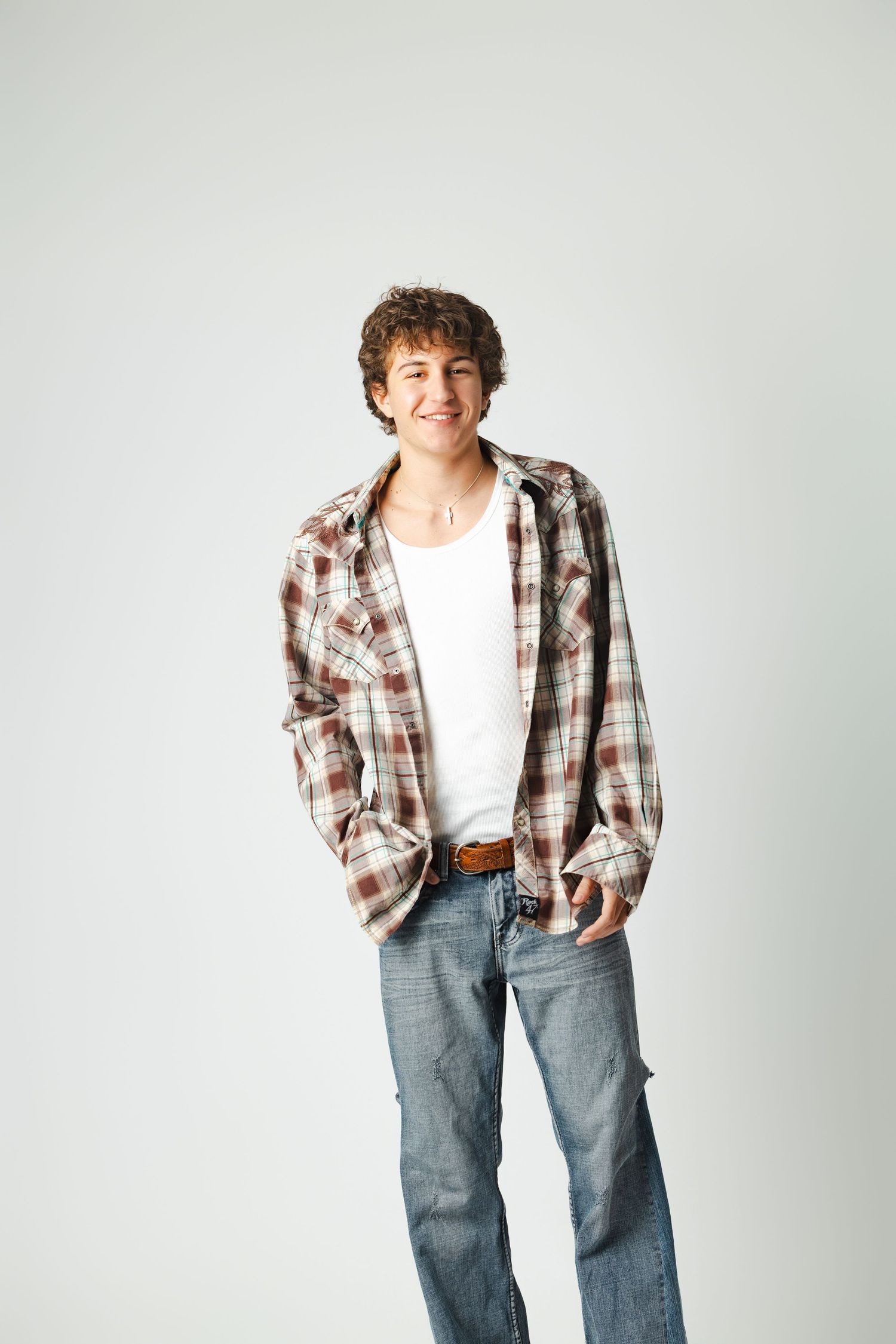 A person wearing a plaid flannel shirt and jeans poses in four similar casual stances against a white backdrop.