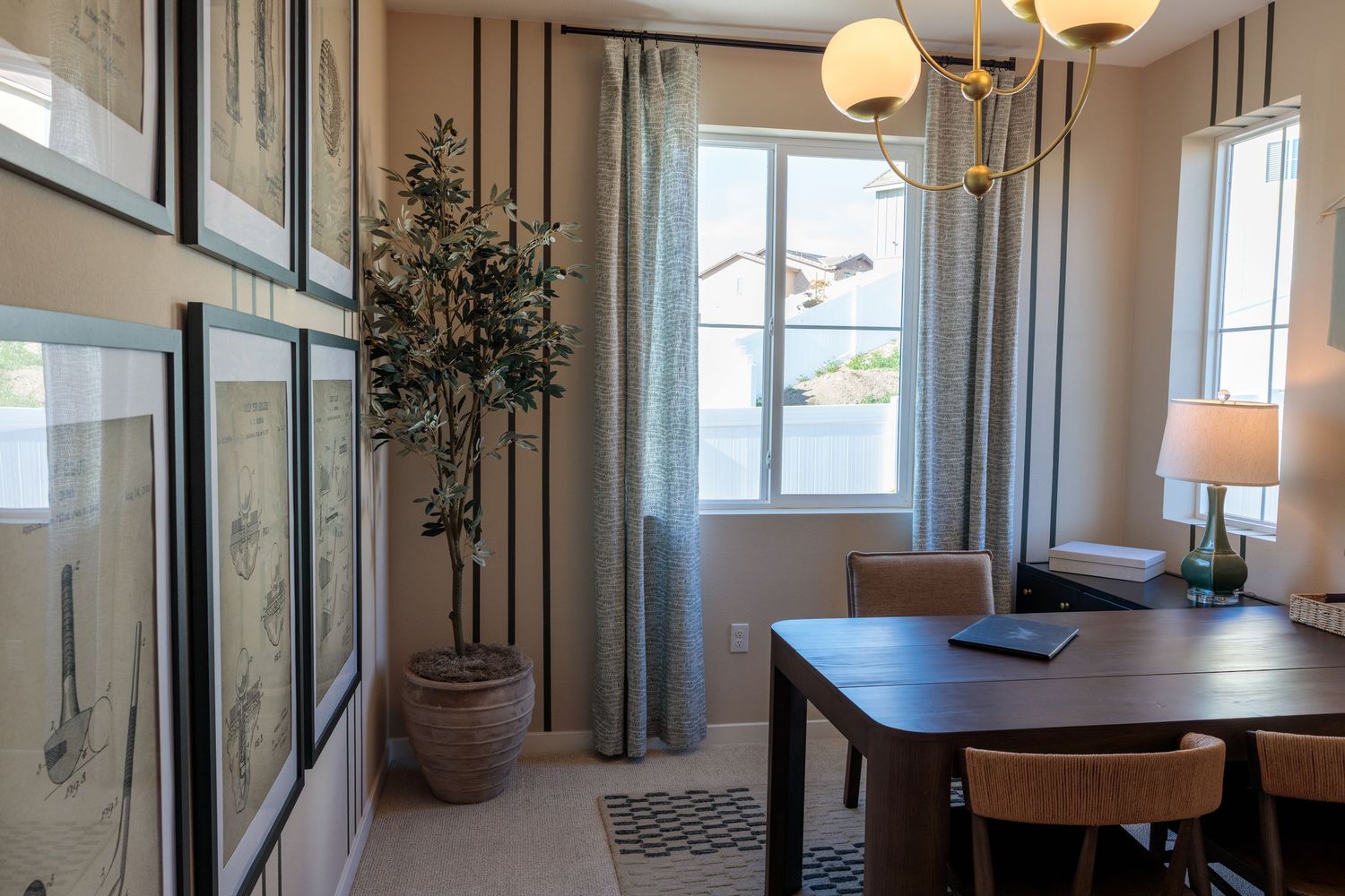 Modern dining room with wood table, globe pendant lights, and large windows overlooking a bright interior space.