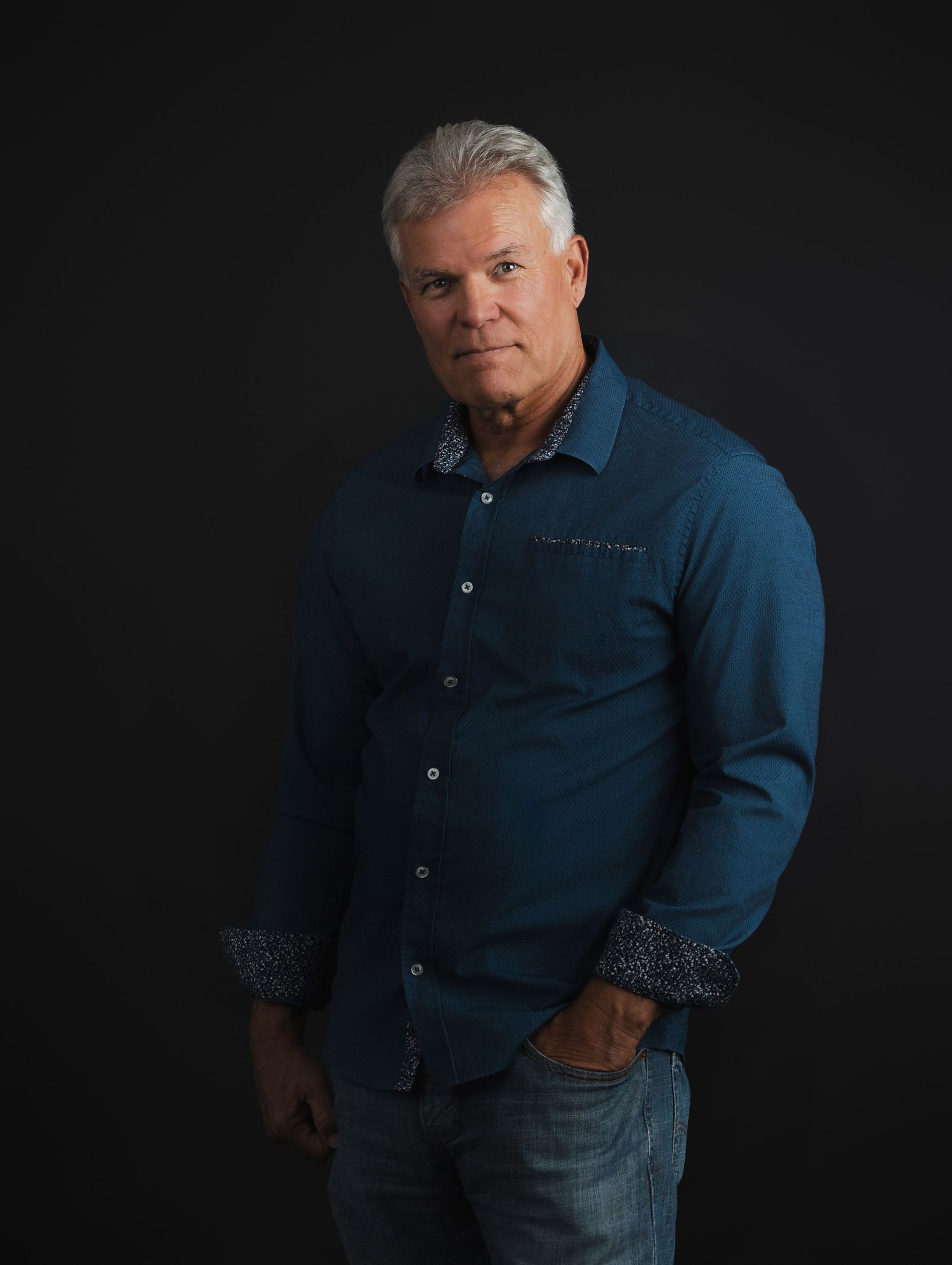 A figure in a navy blue button-down shirt and jeans poses against a dark background in multiple similar poses.