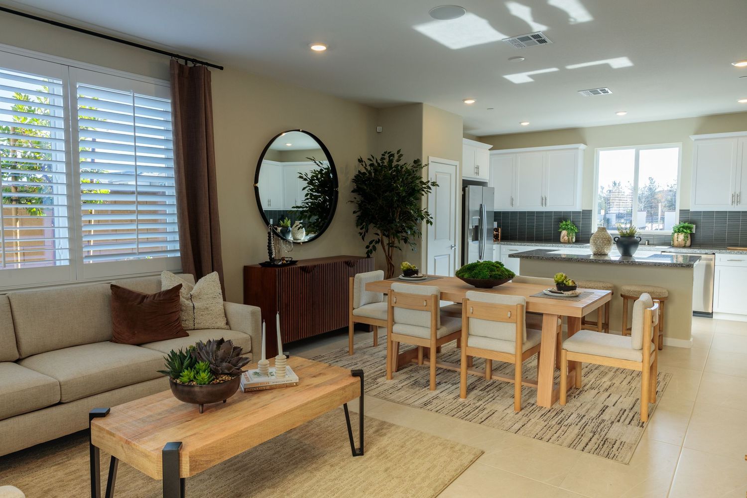 Modern apartment interior with natural light featuring wooden floors, white walls, and minimalist furniture layout.