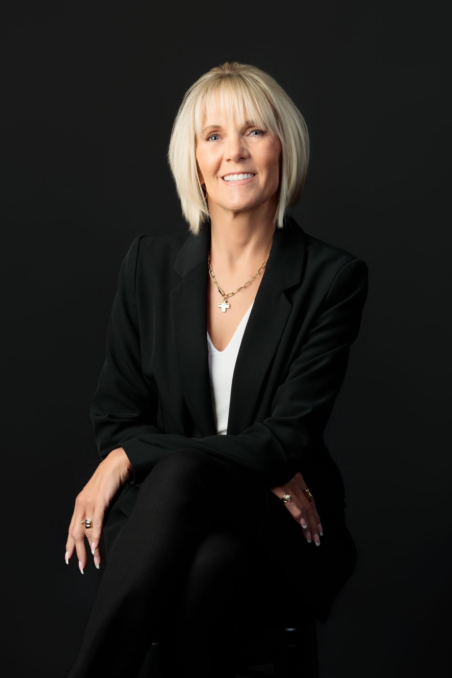 Professional portrait series showing a person in a black blazer and white top against dark background posing expressively.