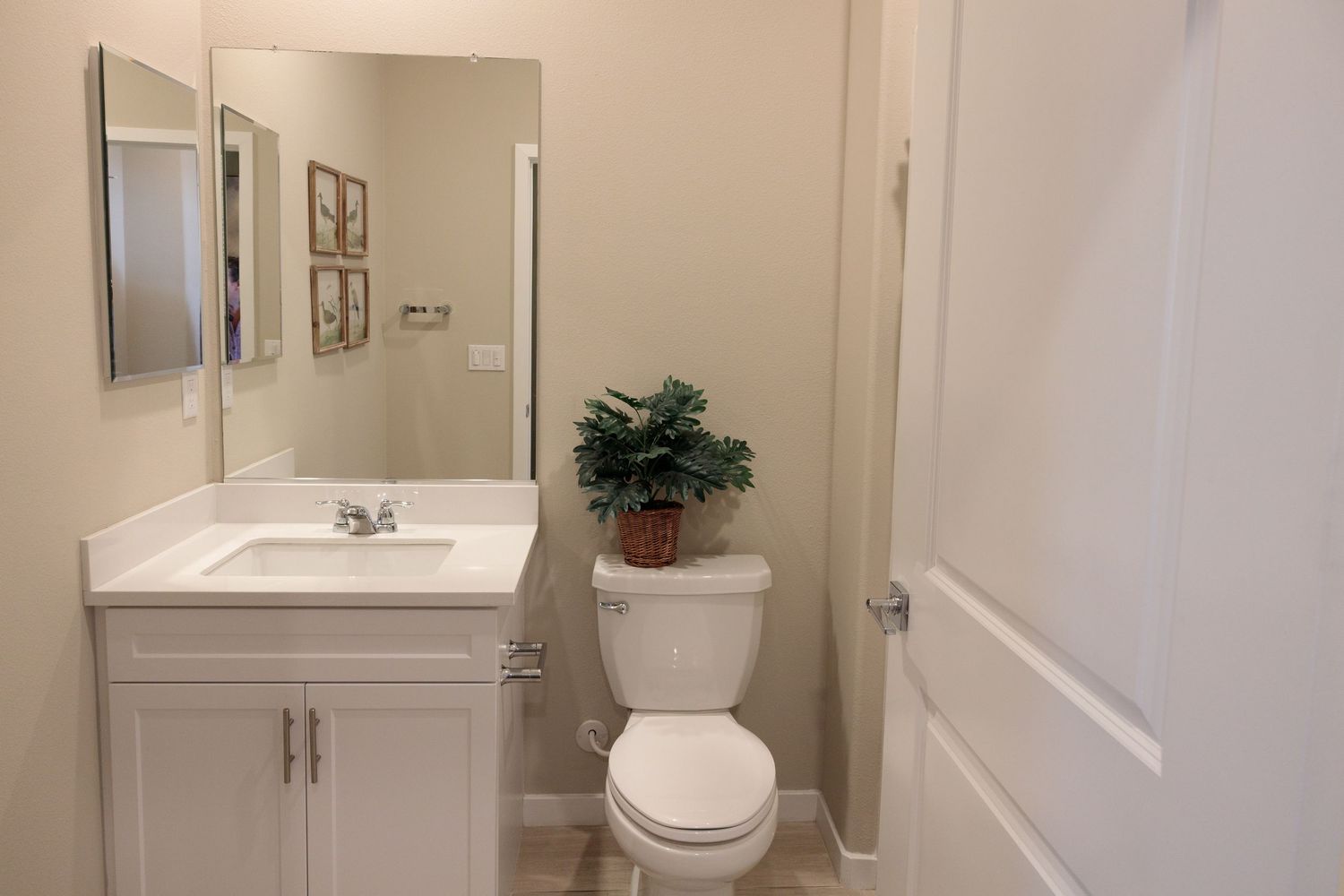 A clean white bathroom interior with modern fixtures, vanity, and tiled flooring in a bright, minimalist style.