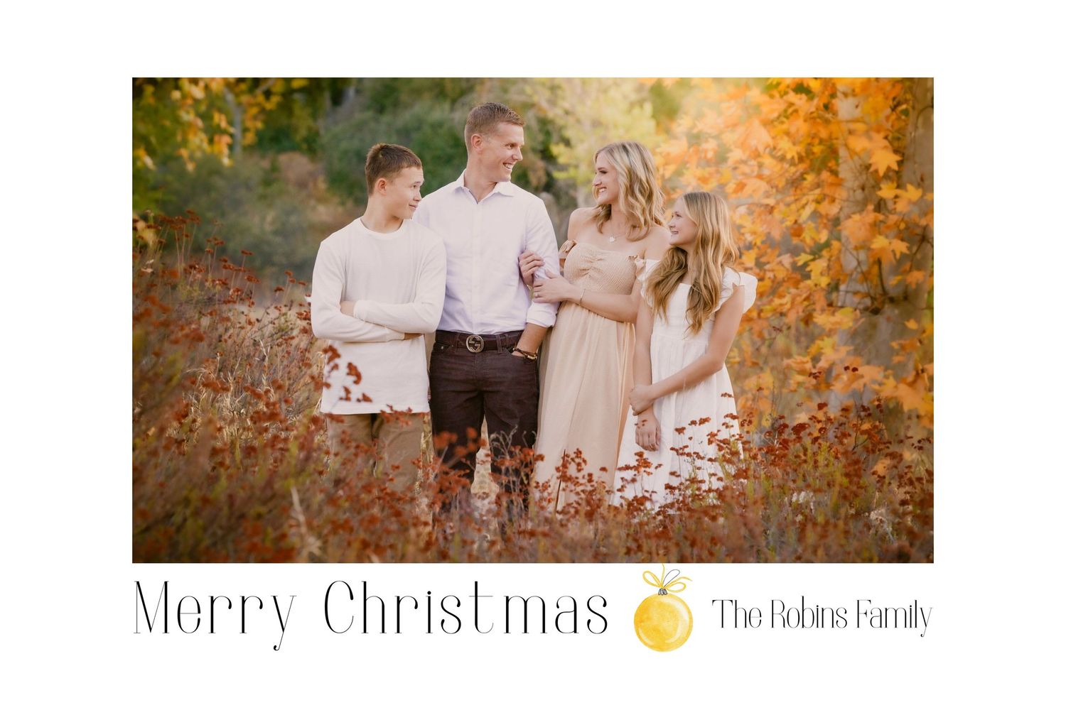 Outdoor family photo session in autumn with golden foliage and warm sunlight creating a festive holiday card design.