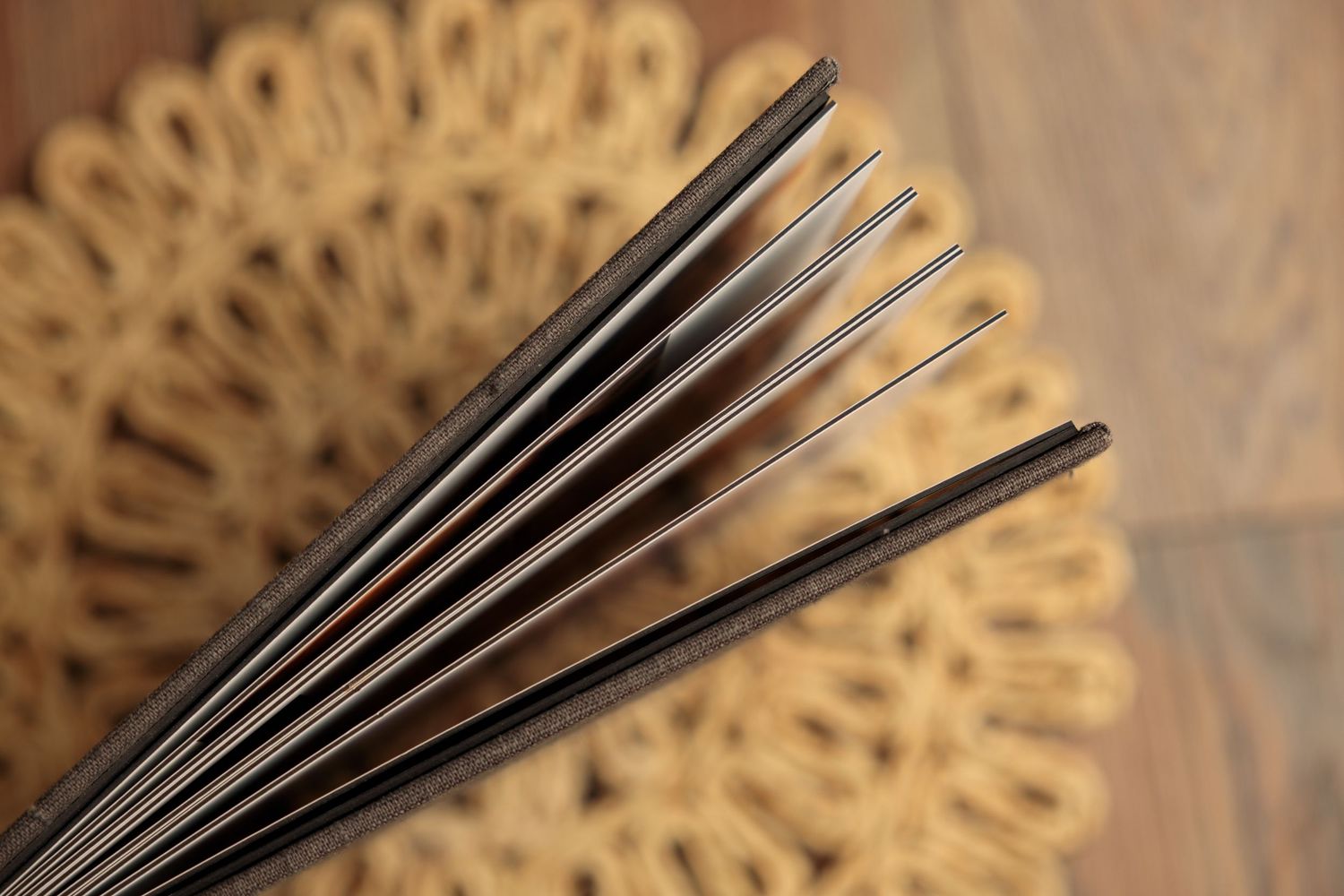 Close-up view of decorative metal fan blades against a warm brown textured background.