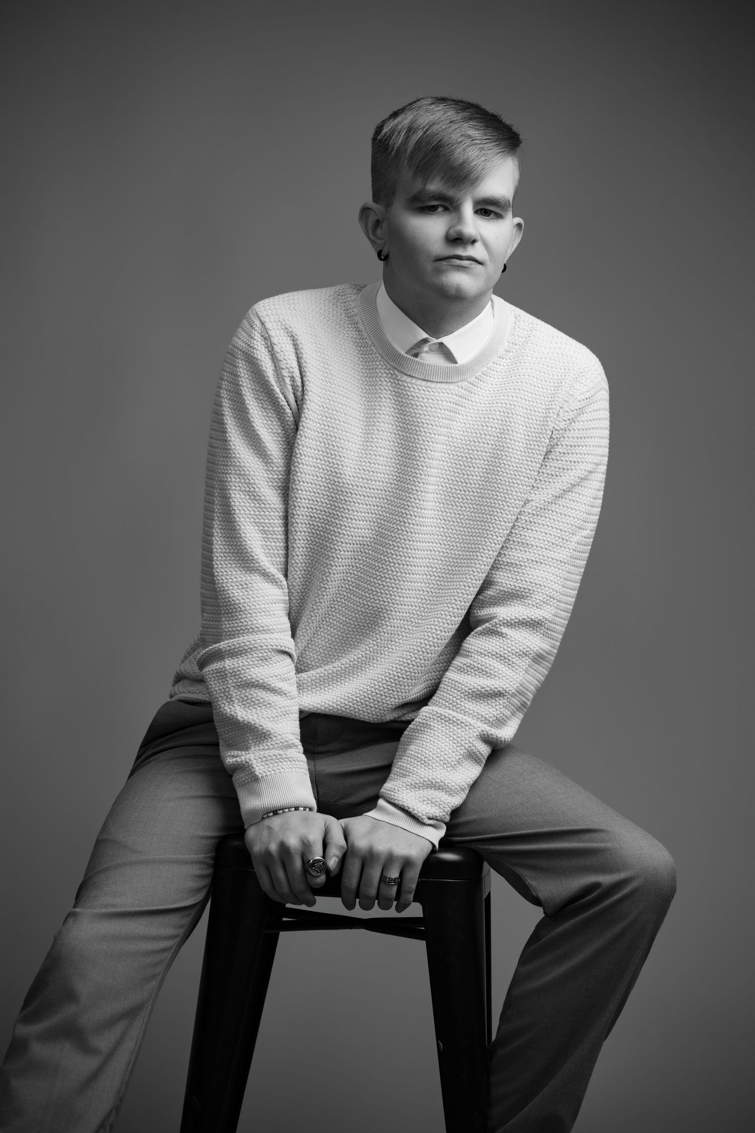 Black and white portrait series showing a person in a white sweater seated on a chair against a dark background.