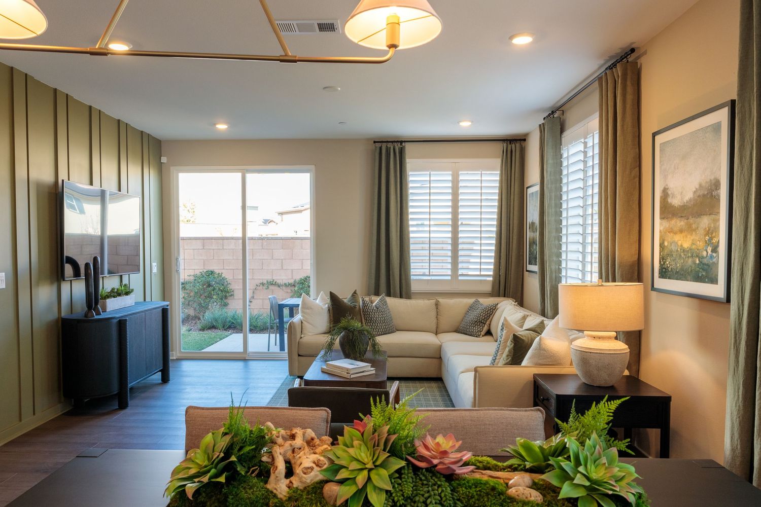 Modern luxury apartment interior with open floor plan featuring recessed lighting, hardwood floors and large windows.