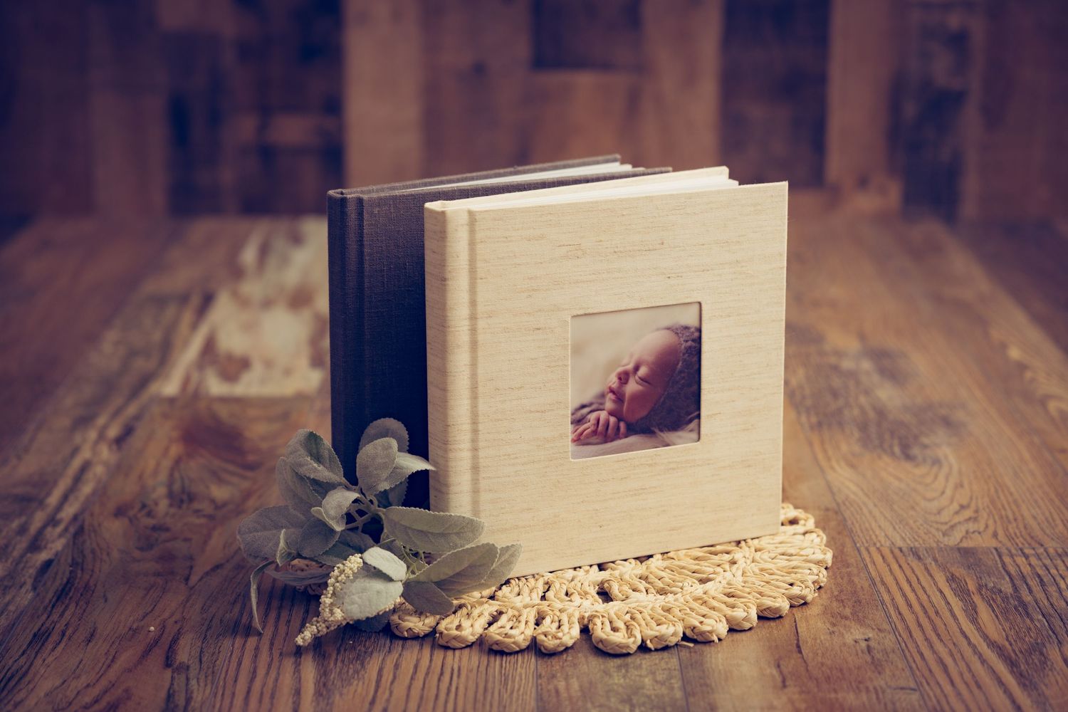 A white hardcover book sits on a rustic wooden table with dramatic lighting and shadows.