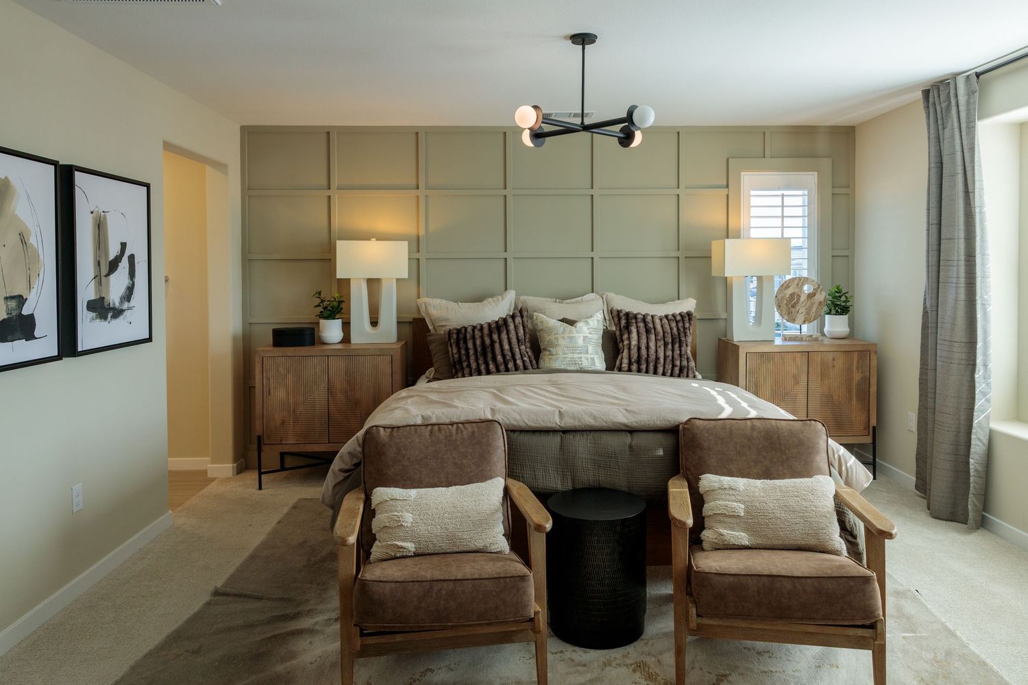 Modern bedroom interior with earth tones featuring twin beds, neutral decor, and contemporary lighting fixtures.