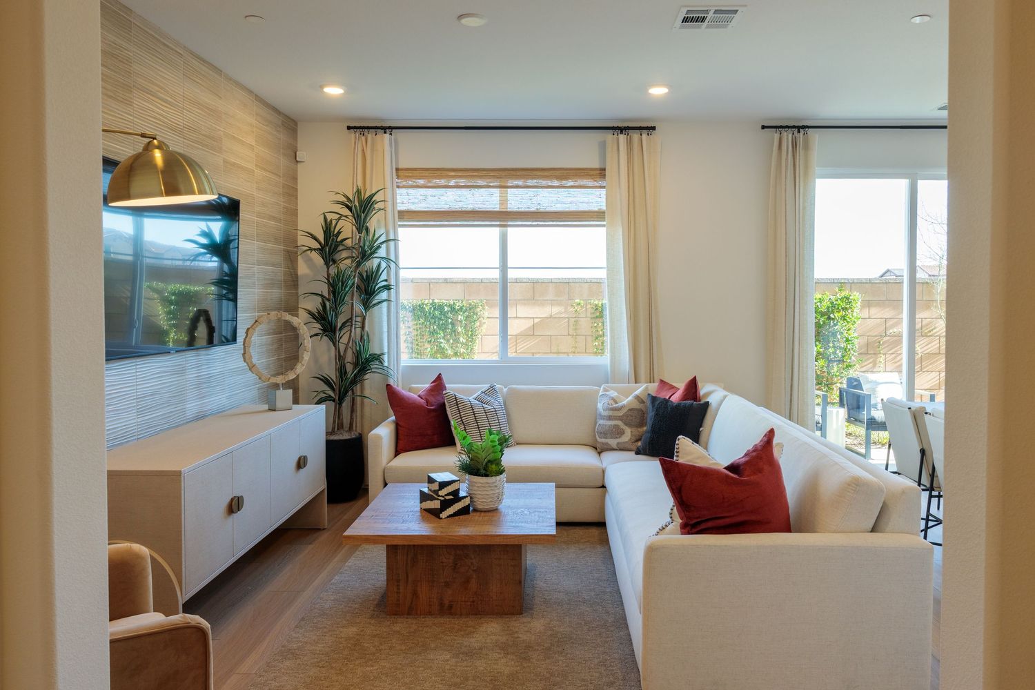 Modern open concept living room with white walls, large windows, and hardwood floors features contemporary furniture and decor.