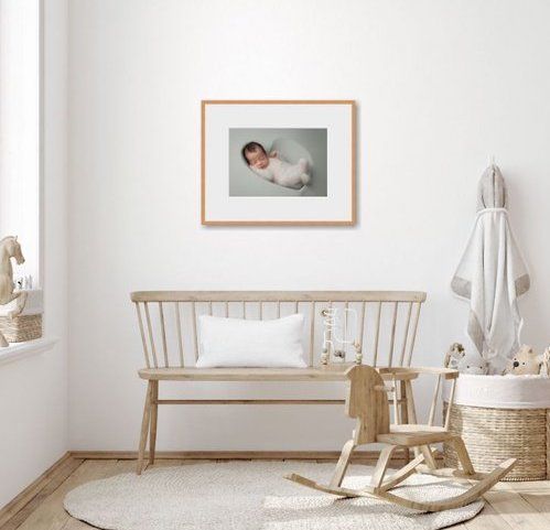 Minimalist nursery room with wooden bench, rocking horse, and framed artwork on white wall. Temecula - Murrieta - Menifee - Corona Photograp