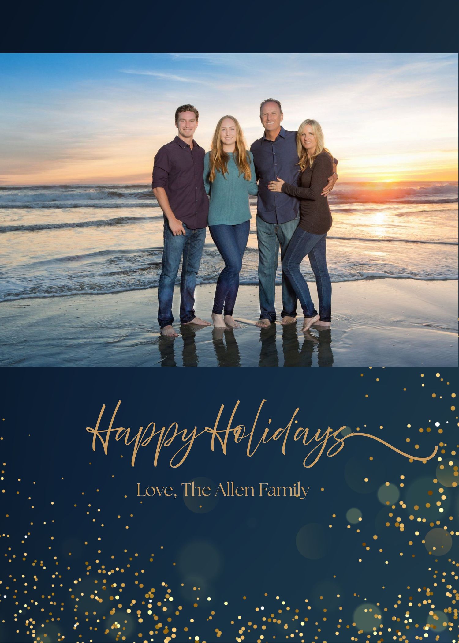 A family poses together on a beach at sunset for their holiday card with navy and gold design elements.