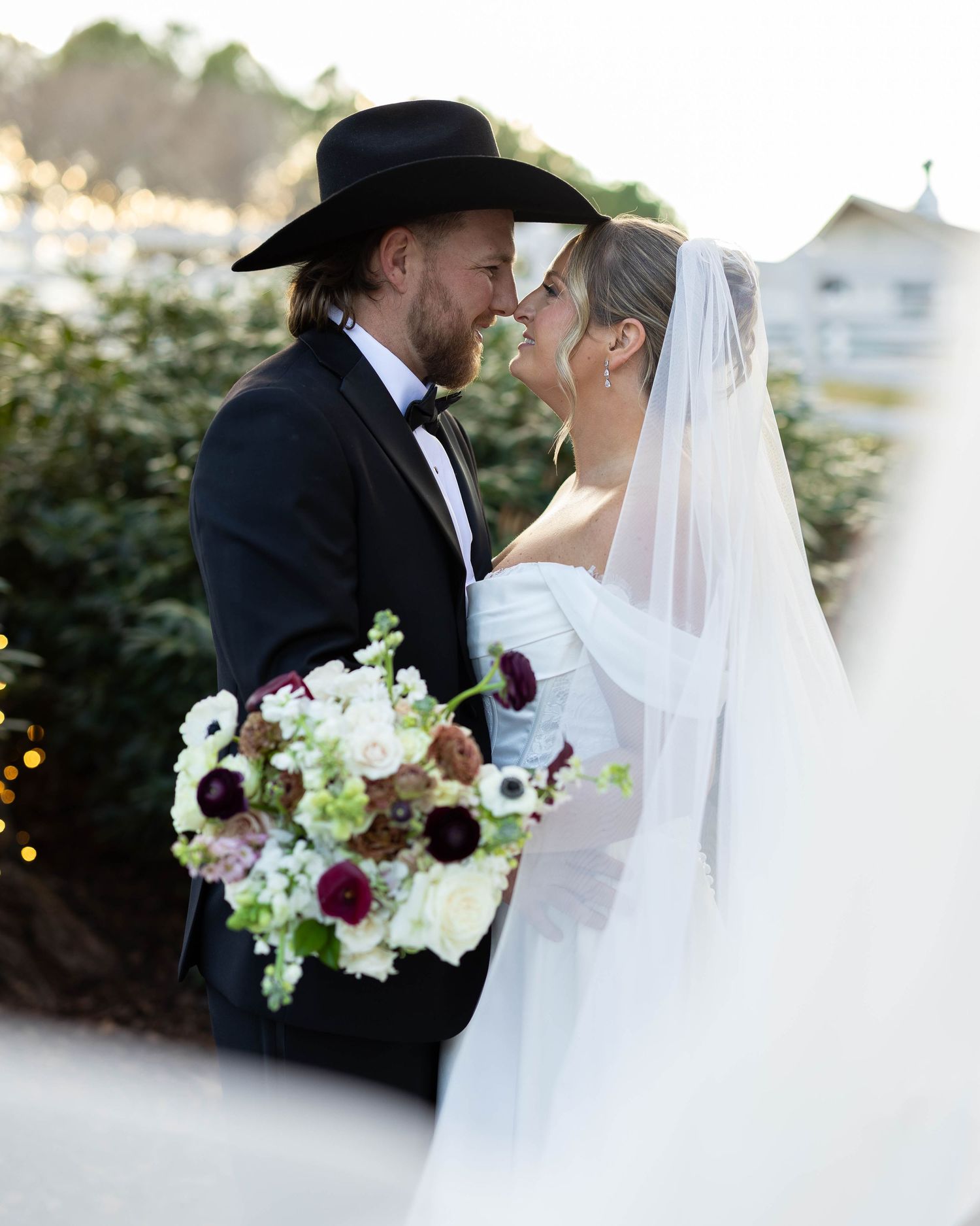 A romantic wedding couple shares intimate moments in a garden setting with soft lighting and floral bouquets.