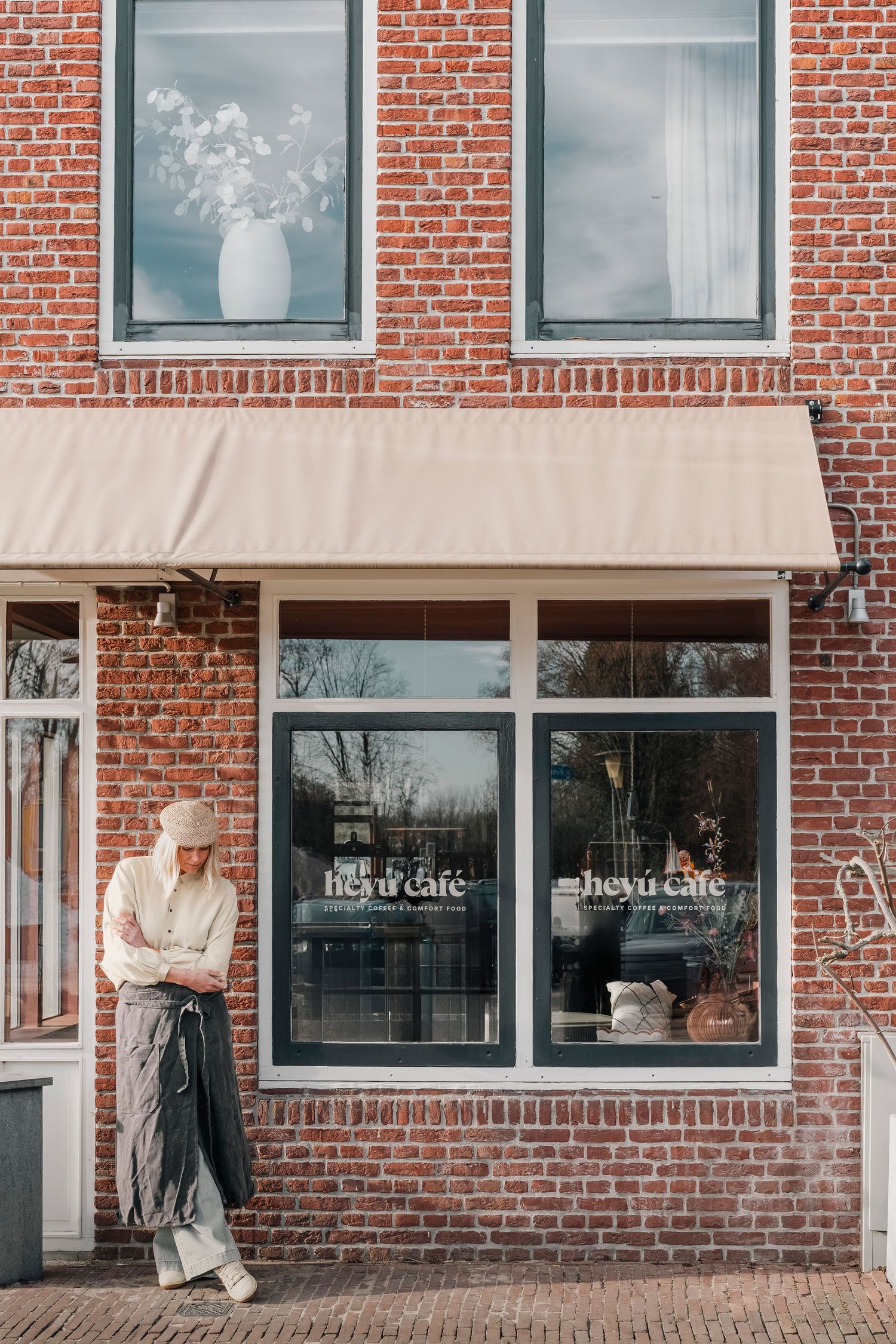 Eigenaresse van Heyu Café voor het pand in Ouderkerk – vol trots in het hart van het dorp. Voorheen Jamie van der Heije, nu Heyú café.