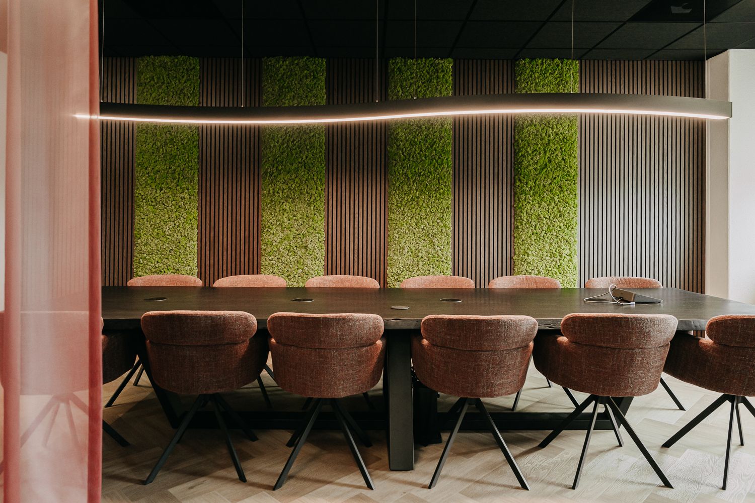Modern en warm kantoorinterieur met een WOOOD zitje en een videoscherm naast de vergadertafel. Vastgelegd door fotograaf Edith Maaskant