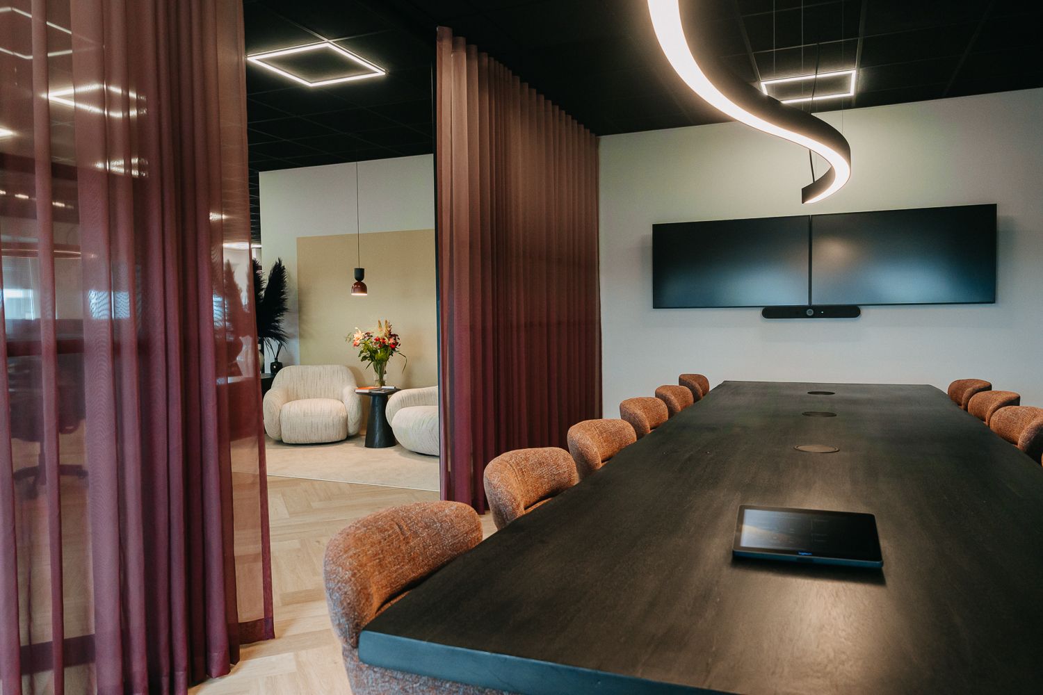 Modern en warm kantoorinterieur met een WOOOD zitje en een videoscherm naast de vergadertafel. Vastgelegd door fotograaf Edith Maaskant
