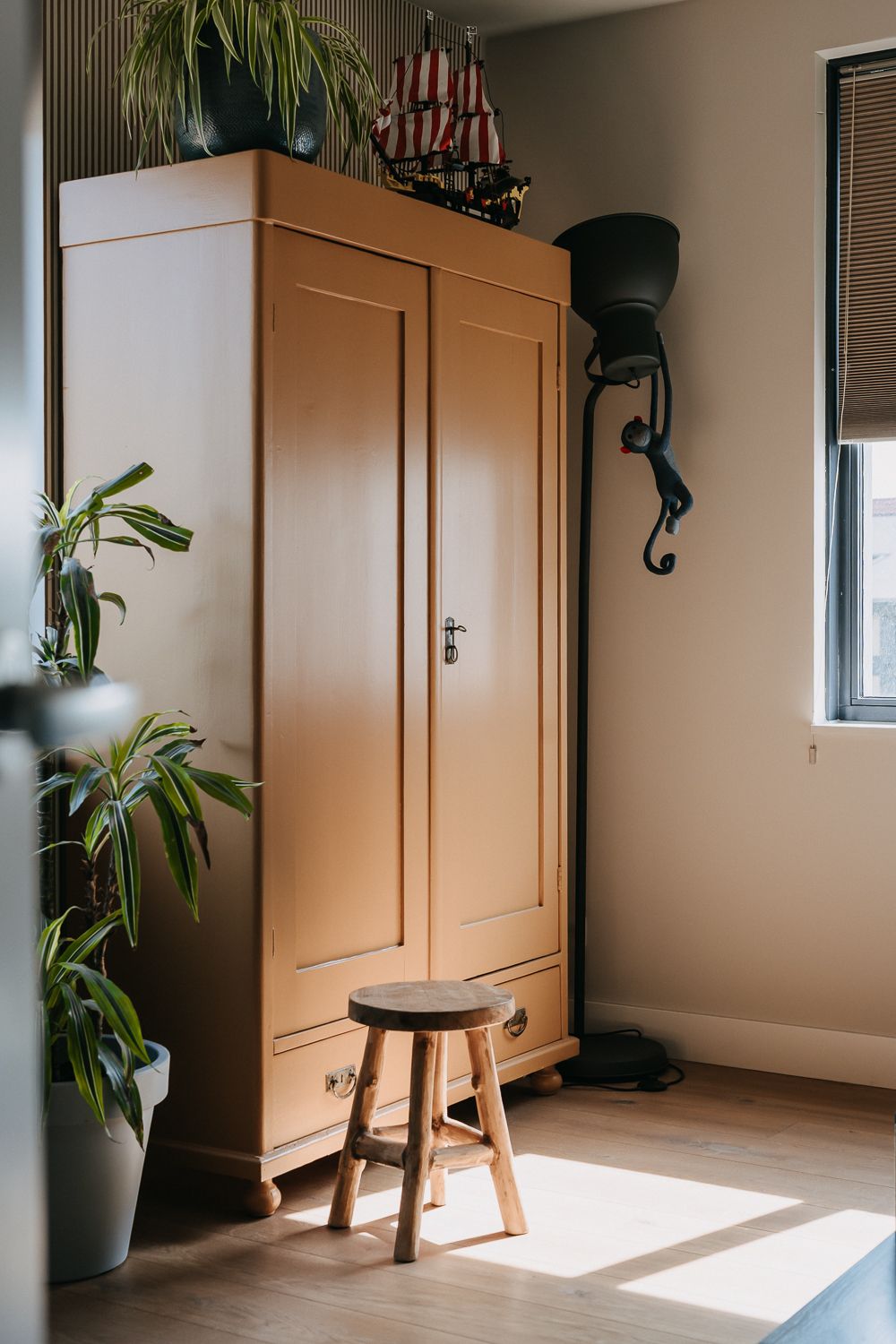 Tienerkamer in rustige stijl, met authentieke kledingkast en behang.