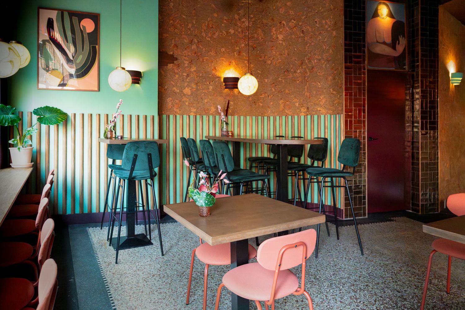 Overzichtsfoto van een tafeltjes, met planten, schilderijen aan de wand en veel kleur. Puerto Burrito interieur shoot.