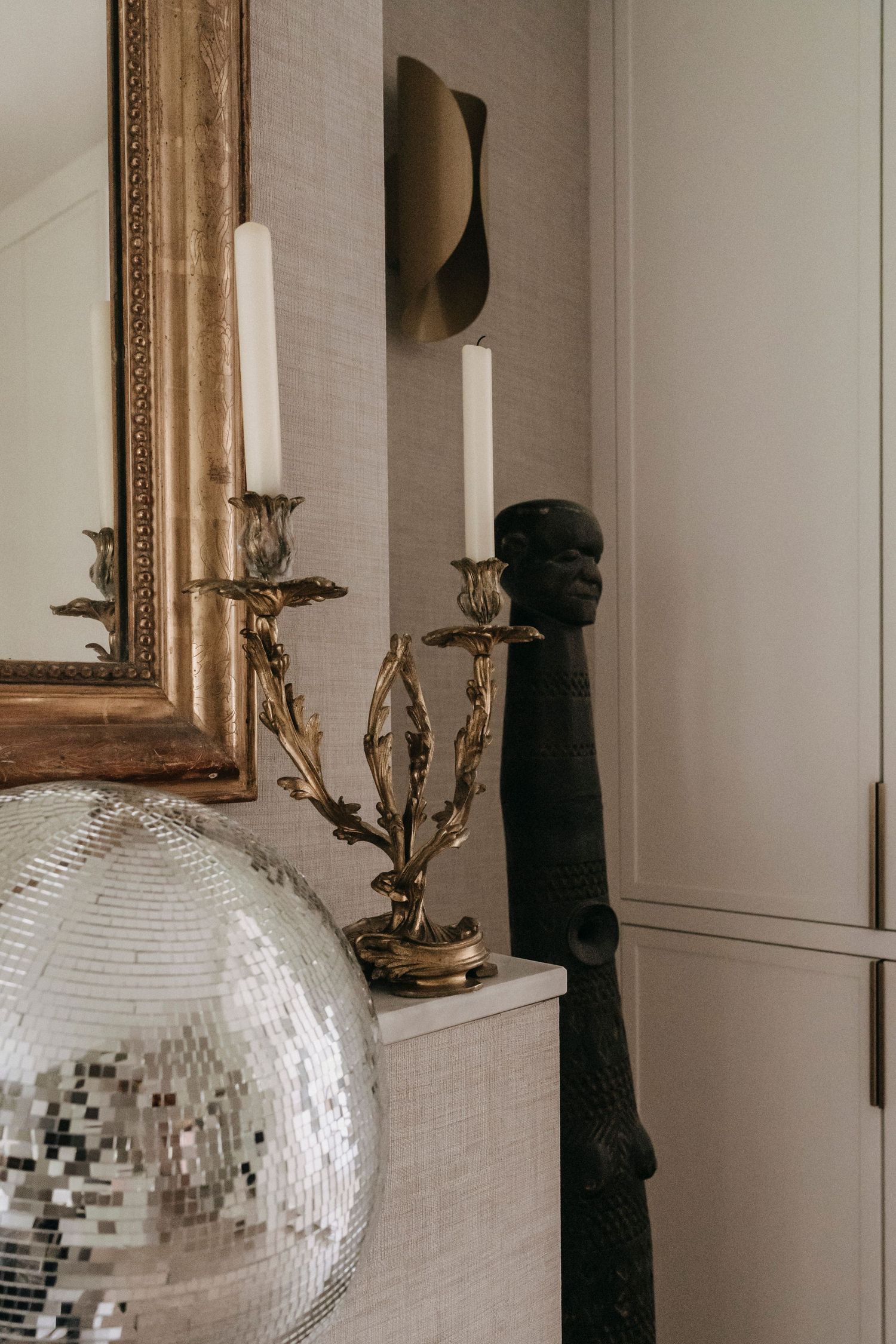Design woonkamer in een jaren ’30 huis in Laren, ontworpen door Sies Interior Design. Met spiegel, glitterbol en afrika souvenirs.