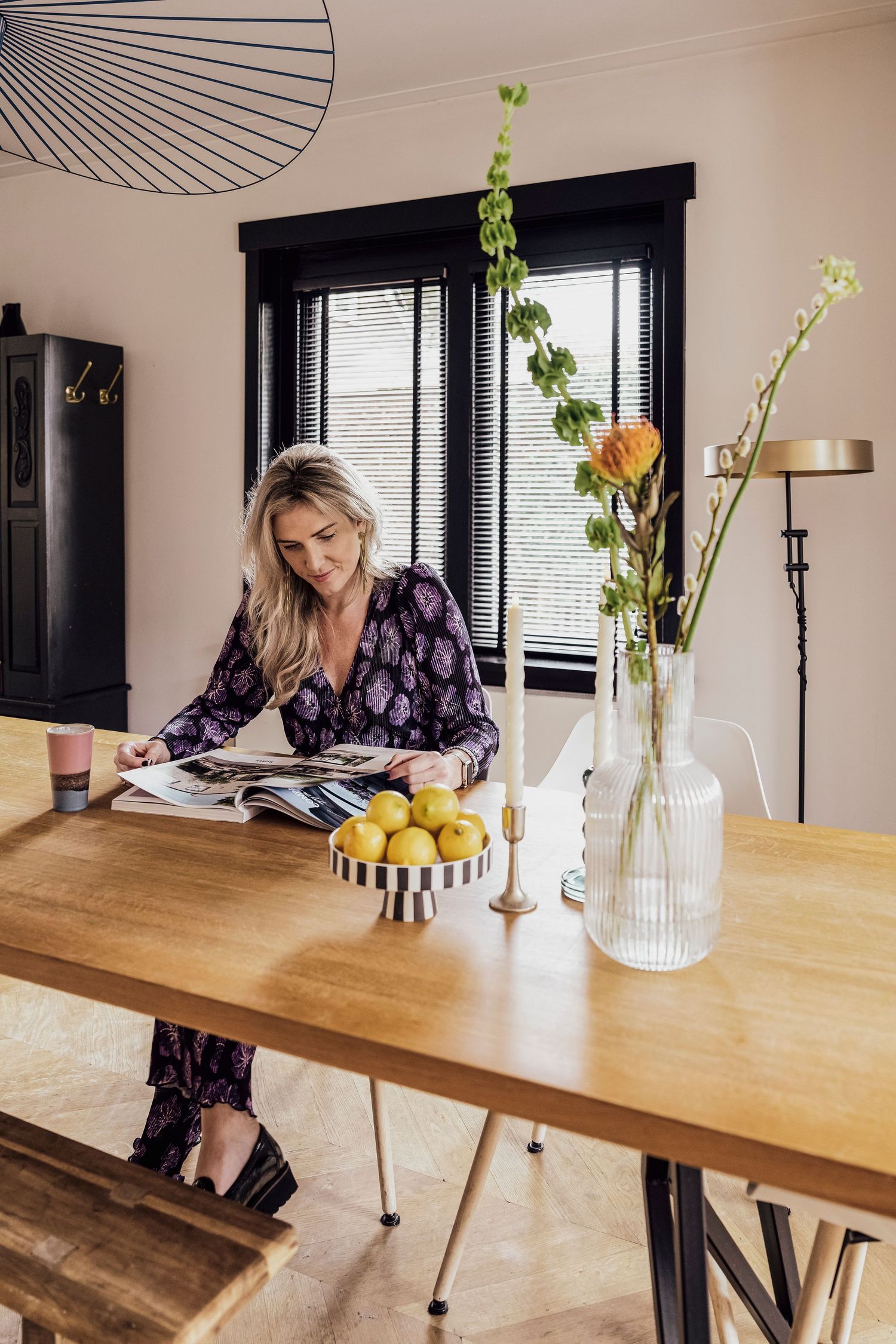 Interieurontwerper oh studio bladert door inspiratie magazines aan een grote houten tafel