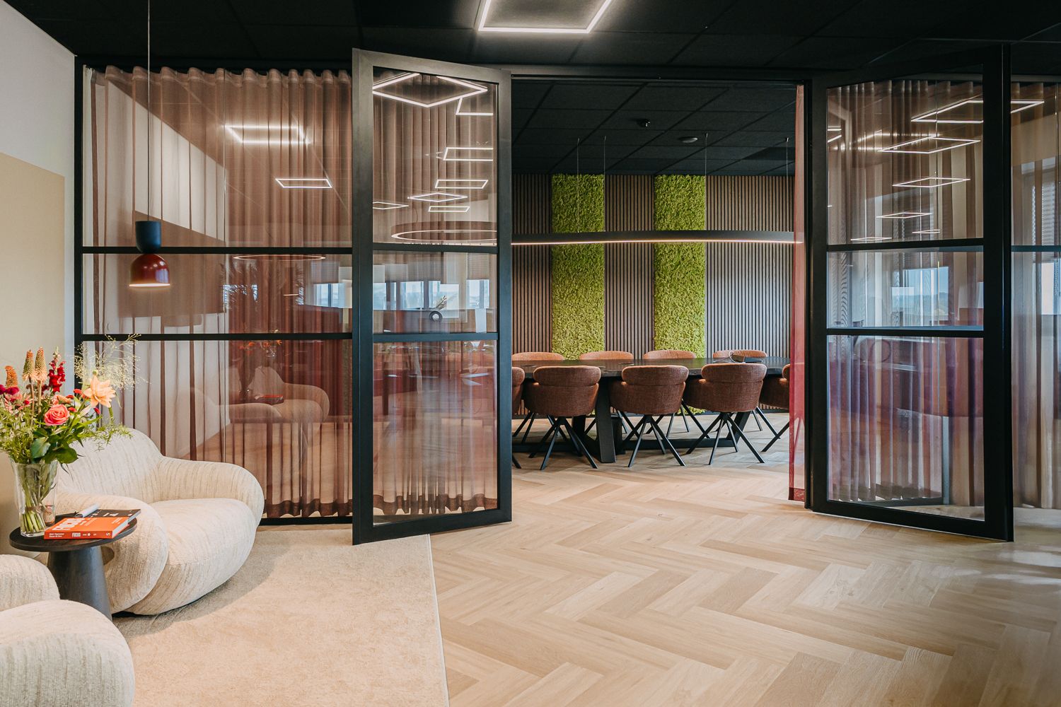 Modern en warm kantoorinterieur met een WOOOD zitje en een videoscherm naast de vergadertafel. Vastgelegd door fotograaf Edith Maaskant