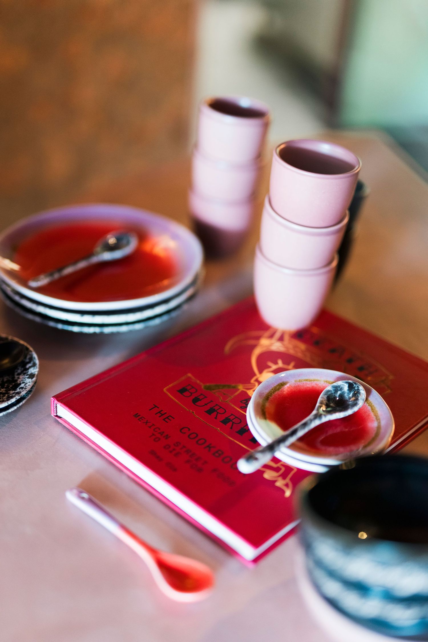 Flatlay van kopjes, schoteltjes en kookboek. Mexicaanse look & feel met rood en roze kleuren. Puerto Burrito restaurant Hilversum