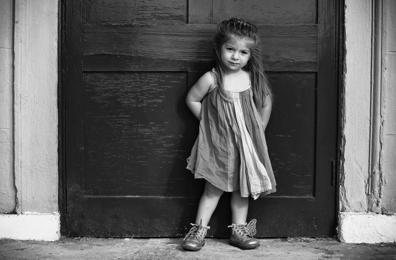 A pretty young girl stands for a portrait in a park. Prestwich, Manchester, UK.
