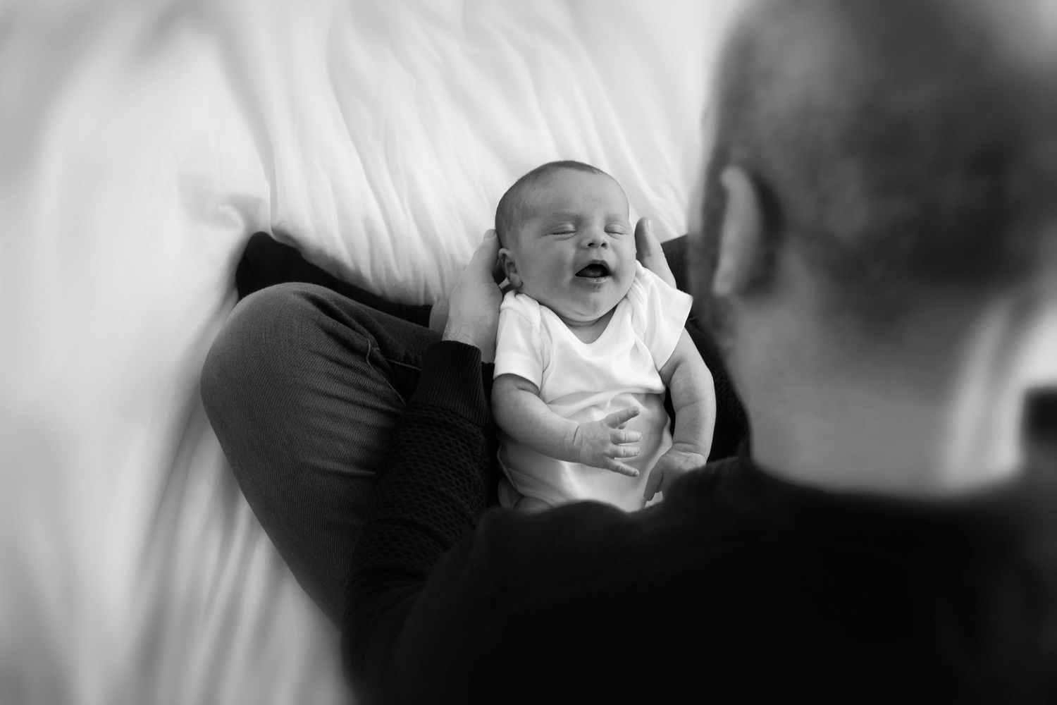 Father holding his newborn baby during a peaceful session in their home in Prestwich, Manchester