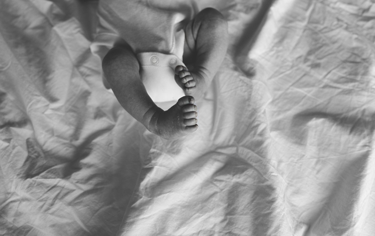 Black and white photograph of a close up of a baby's foot during a newborn photoshoot in Manchester.